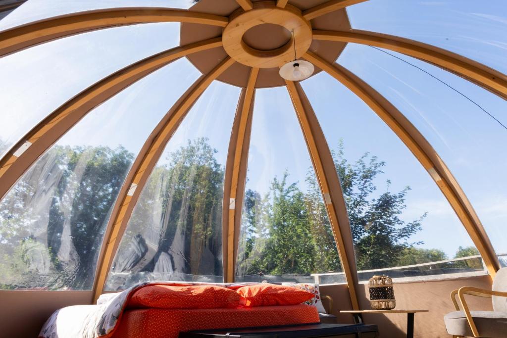a room with a large window with a bed in it at La sphère étoilée in Ames
