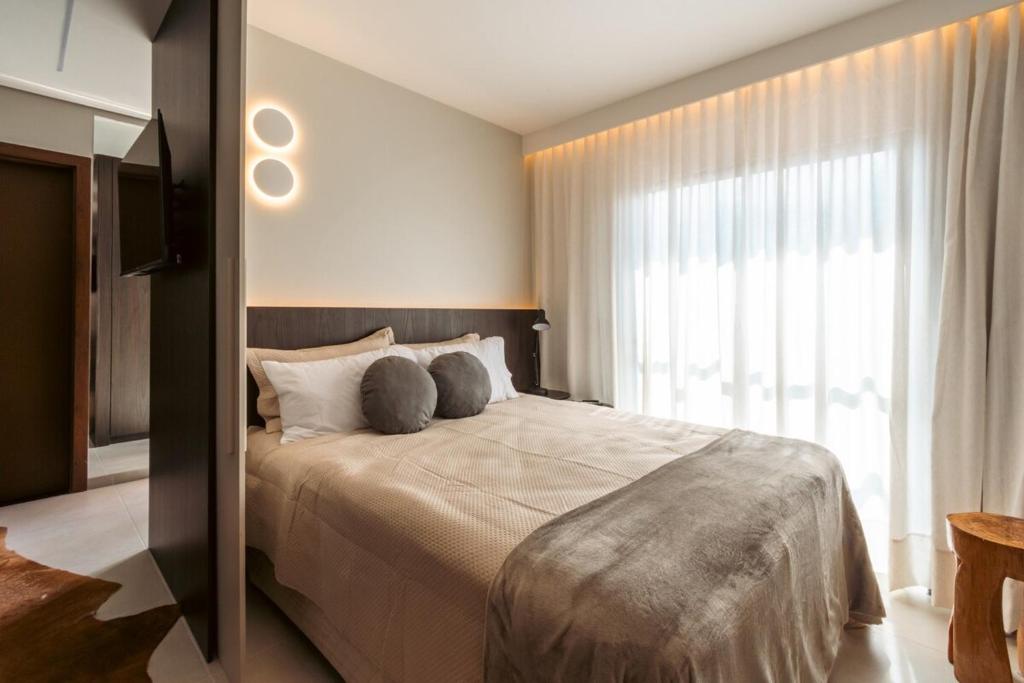 a bedroom with a large bed and a large window at Studio Luxuoso com vista surpreendente in Macapá