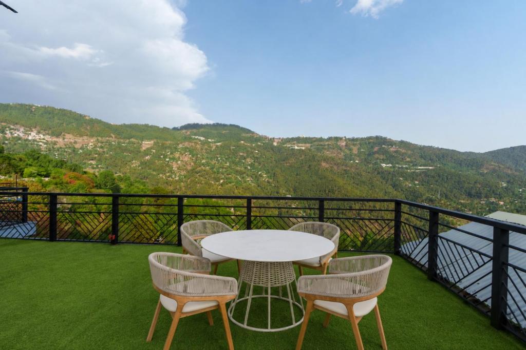 a table and chairs on a balcony with a view at 3 BEDROOMS Premium Private Cottage In Murree Mountains in Murree