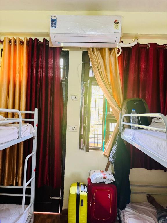 a room with two bunk beds and luggage at Awara Hostels and Dormitory in Lucknow