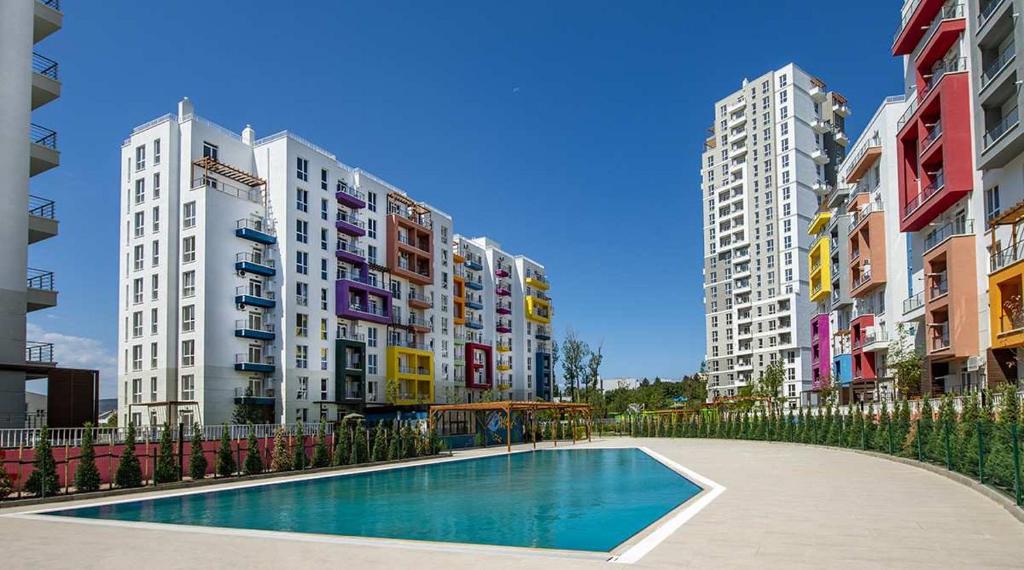 a swimming pool in a city with tall buildings at My Sweet Apartment in Tbilisi City