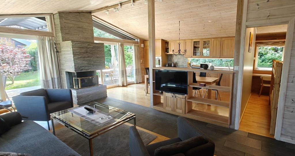 a living room with a couch a table and a television at Villa Verde by Hvalstrand beach in Nes
