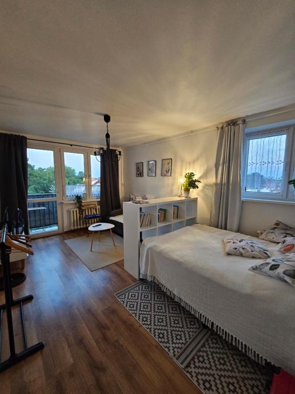 a bedroom with a bed and a desk and windows at Blick auf die Kirche in Wschowa