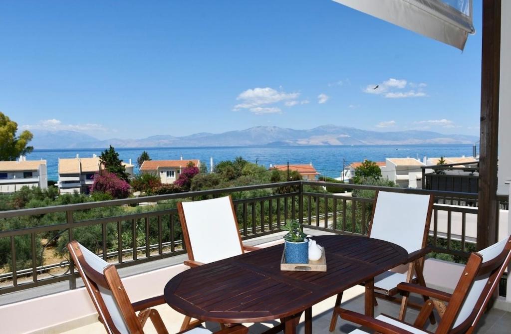 a table and chairs on a balcony with a view of the ocean at Kyma&Soul Seaview Loft in Xylokastro