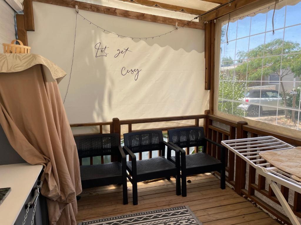 a screened in porch with two chairs and a window at Mon nid douillet in Valras-Plage