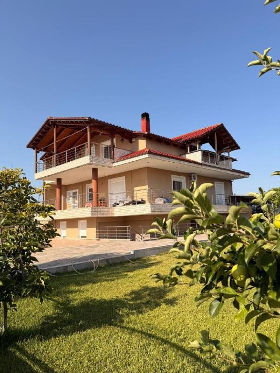 a large house on top of a grass field at Sonya Apartments in Mesochórion