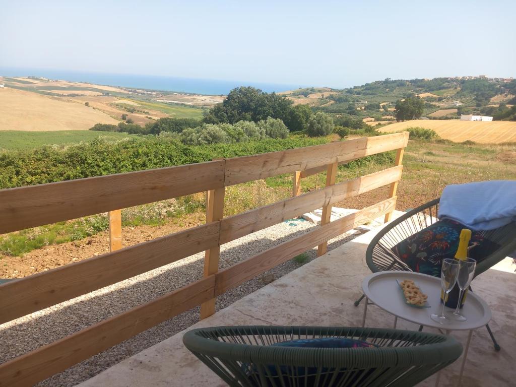 a patio with a table and chairs and a fence at Parthenope in Petacciato
