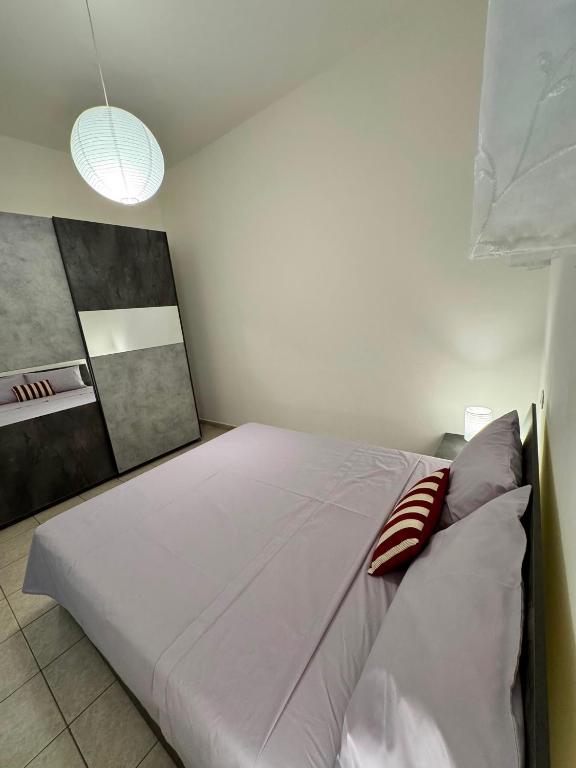 a bedroom with a large white bed in a room at Hour Home in Iglesias