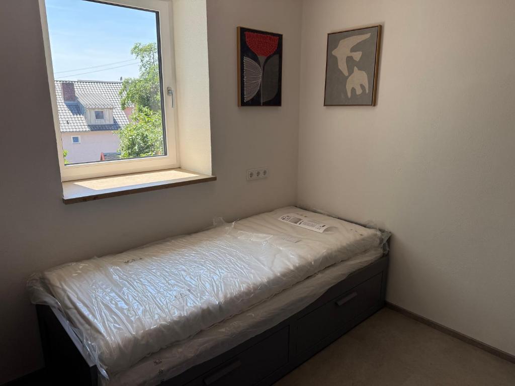a small room with a bed and a window at Baumannhaus in Ziemetshausen