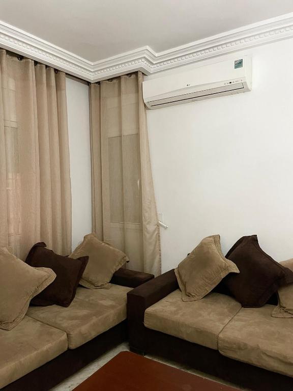 a living room with a couch with pillows on it at Sweet Home in Tunis