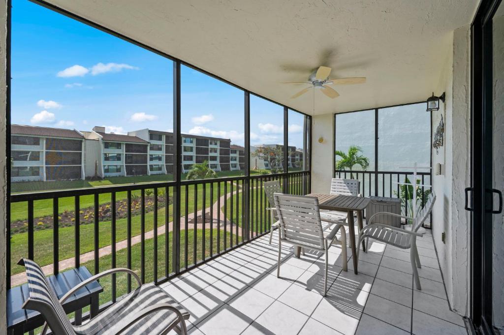 a balcony with a table and chairs and a view at Beachfront End Unit 302 2 Bikes beach gear in Sanibel