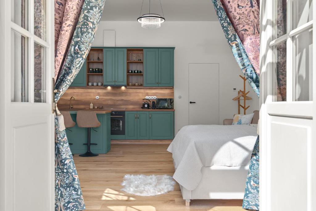 a kitchen with green cabinets and a bed in a room at Zámecký Apartmán Verde in Jince