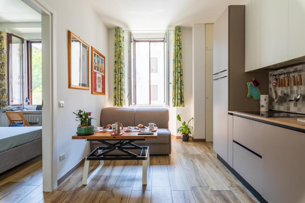 a small living room with a table and a couch at Casa DiMì - 2 BR, 2 en-suite bath, 2 min M5, Smart lock in Milan