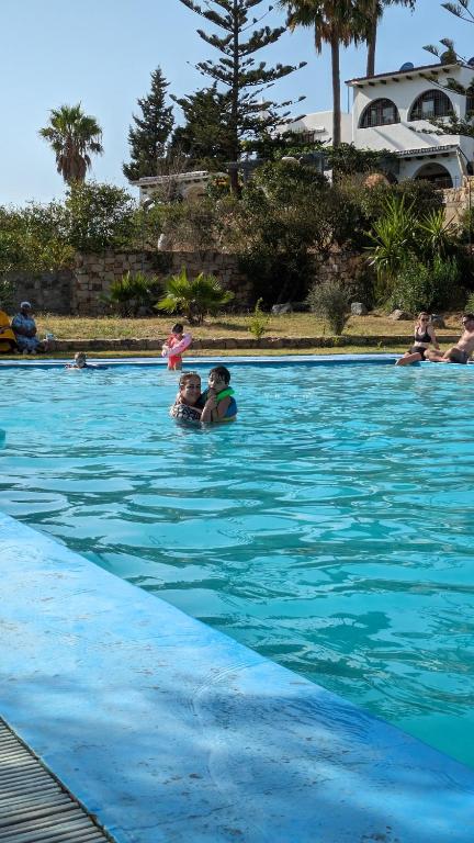 a group of people swimming in a swimming pool at Villa Saif in Marina Smir