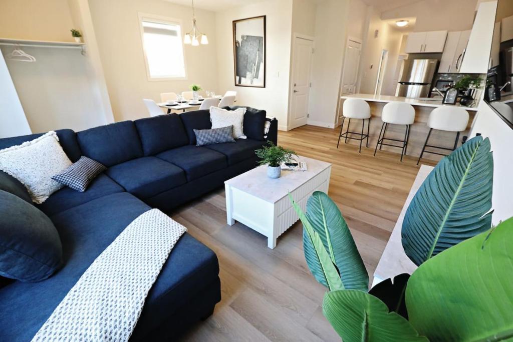 a living room with a blue couch and a table at Central 3 Queen Beds AC Double Garage Disney in Edmonton