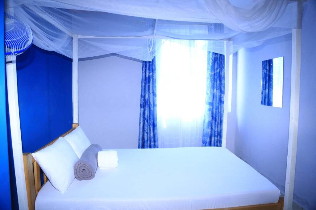 a bedroom with a white bed with a window at La Bella resort in Mombasa