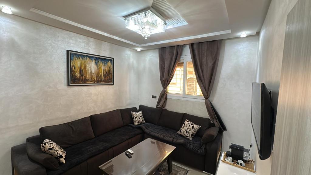 a living room with a couch and a television at Appartement Agadir T2 pour couples maries et familles in Agadir