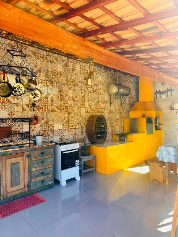 a kitchen with a yellow stove and a wall at Cheiro de Flor - Gamarra in Baependi