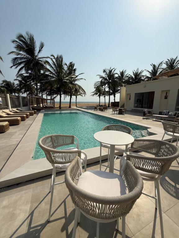 a swimming pool with chairs and a table and a table at Atlantic Shores Resort in Igbolobi