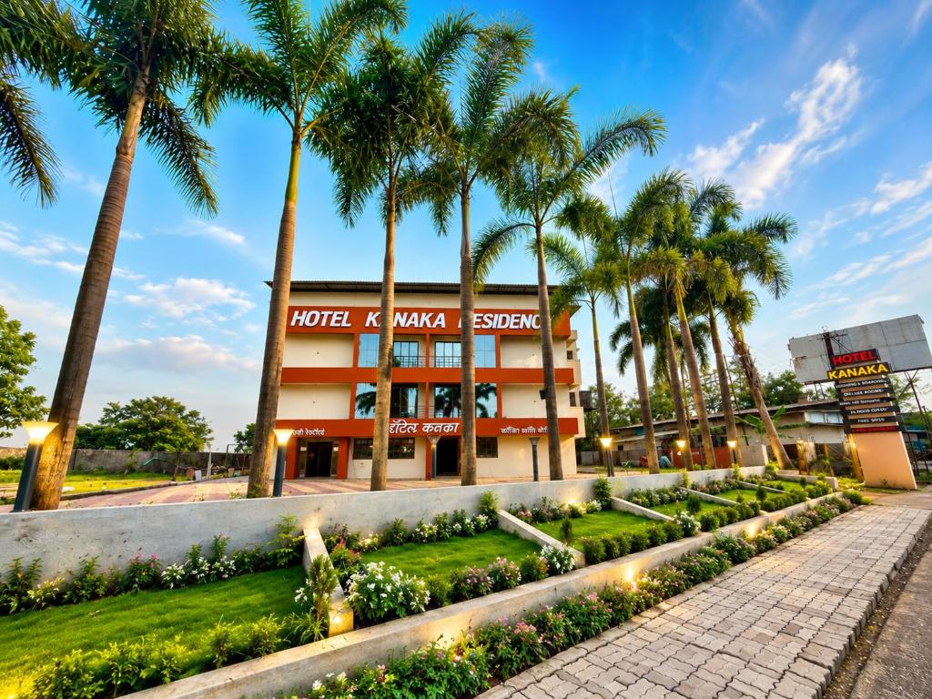 a hotel with palm trees in front of a building at Hotel Kanaka Residency in Mangrul