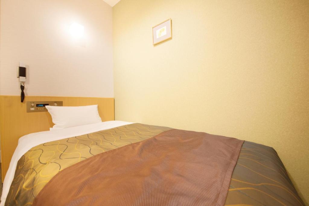 a bedroom with a bed in a room at Hotel Grand City in Tokyo