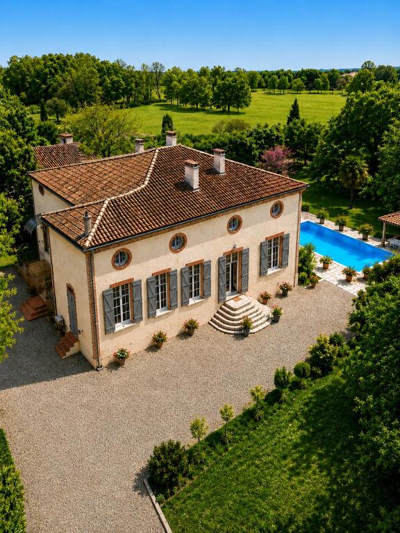 an aerial view of a house with a swimming pool at Manoir de La Gravette Authentic French Manor Experience in Montauban