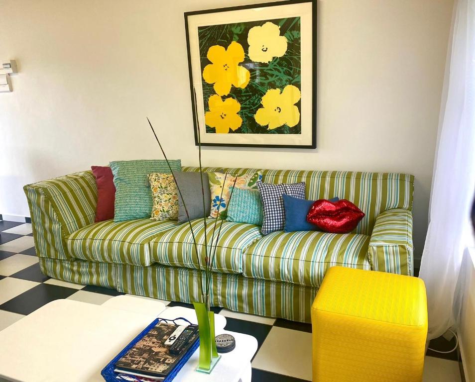 ein Wohnzimmer mit einem grünen Sofa und einem gelben Hocker in der Unterkunft Die Ateljee in Glentana