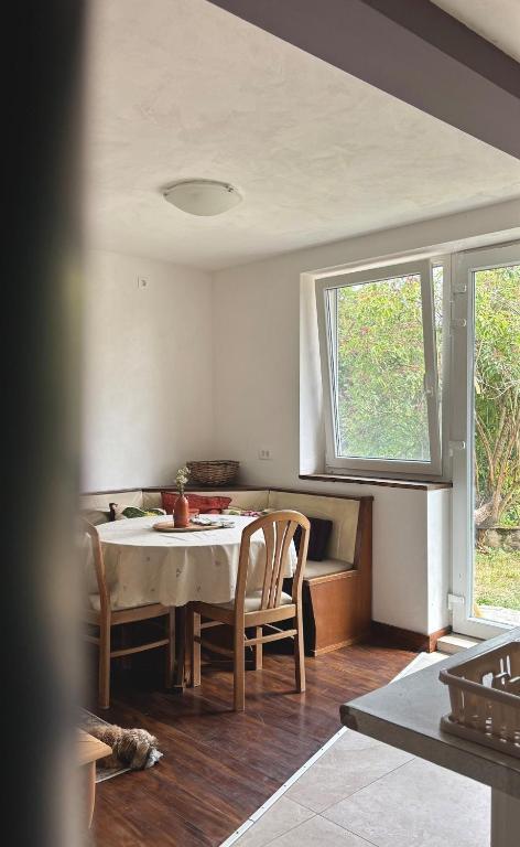 a dining room with a table and chairs and a window at Apartment Volk Turjaški in Gabrovka