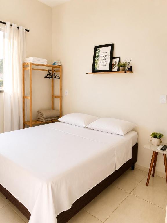 a bedroom with a large white bed in a room at Ap7 - Studio Completo a Minutos das Compras no Paraguai in Guaíra