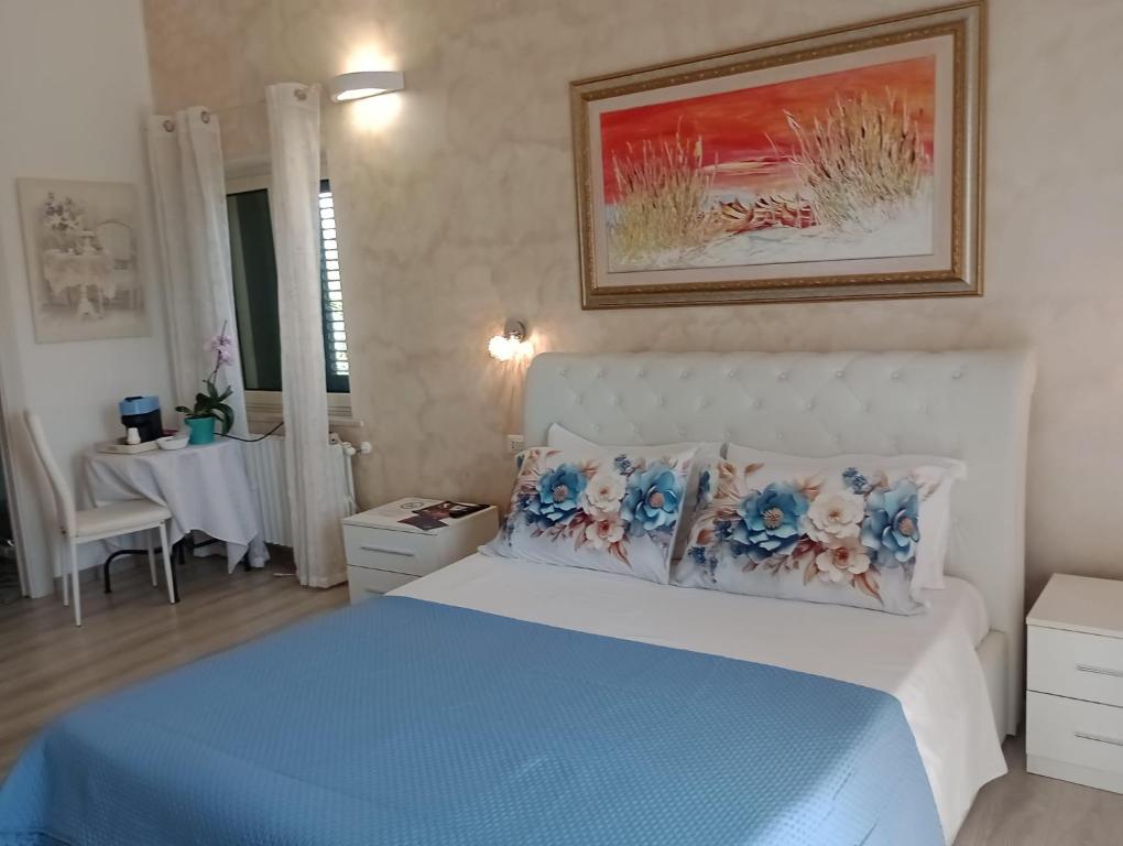 a bedroom with a bed with blue sheets and pillows at Viola di Mare Rooms and Parking in Termoli