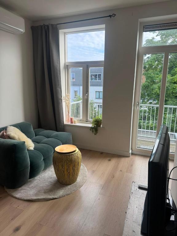 a living room with a blue couch and a large window at Modern Design Apartment with Balcon in Nijmegen