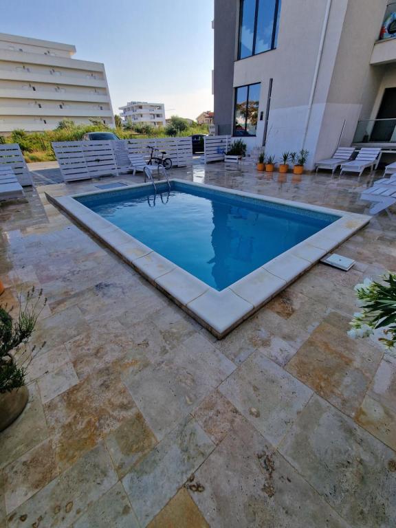 a swimming pool in the middle of a patio at Seb apartment mamaia nord in Năvodari