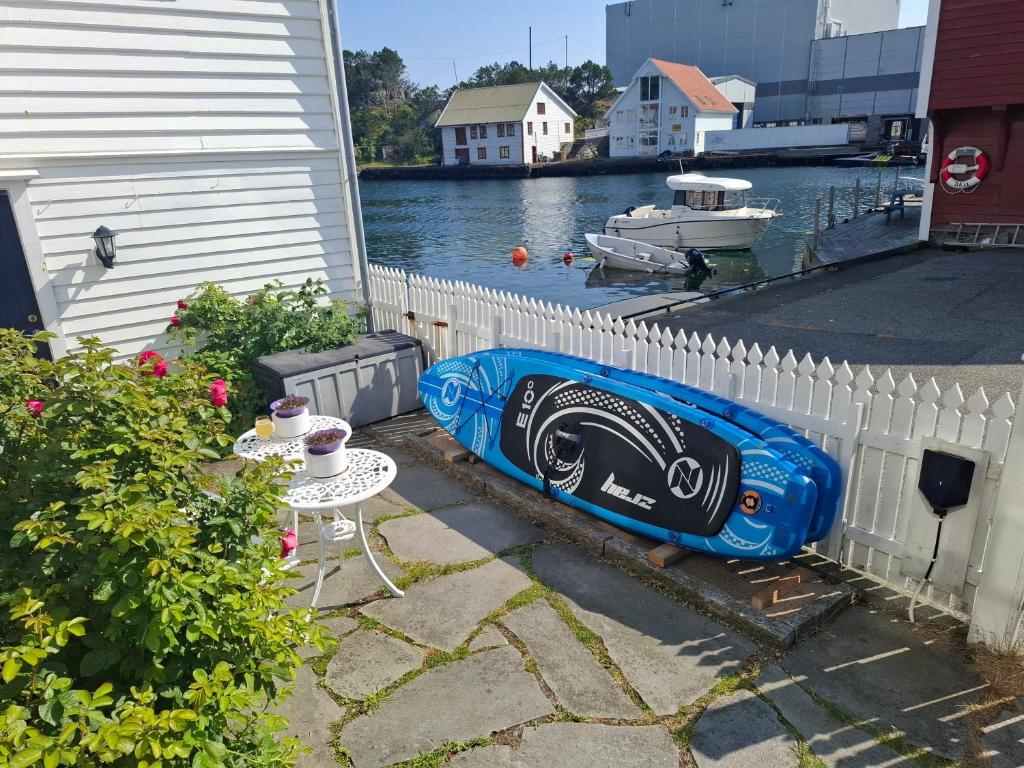 a blue kayak sitting on the side of a fence at Ocean Front Garden in Skudeneshavn