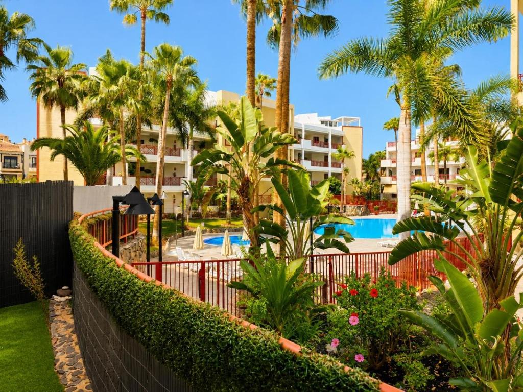 a view of a resort with palm trees and a swimming pool at Oasis Palm Mar by HelloApartments in Palm-Mar