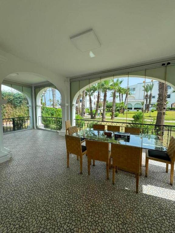 a dining room with a glass table and chairs at Marina Puerto in Marina Smir