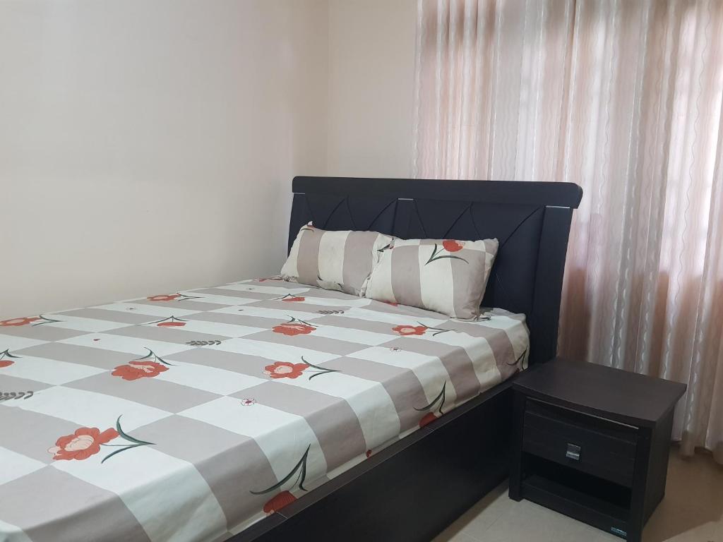 a bedroom with a bed with a floral comforter at Calm Cottege in Gampaha