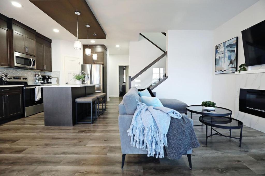 a living room with a couch and a kitchen at Three King Beds Central AC Fireplace Park Disney in Edmonton