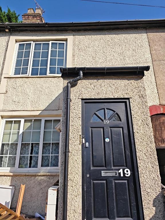 a black door on the side of a house at Shriji Homes in Watford West Station