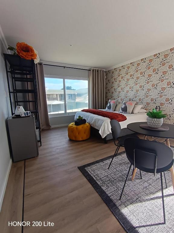 a bedroom with a bed and a table and chairs at Weskusbokkompie in Velddrif