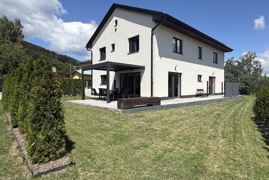 a large white house with a large yard at Wellness Chalupa Hayek in Česká Ves