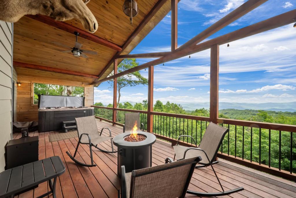 a deck with chairs and a table with a fire on it at Viewtopia in Beech Mountain