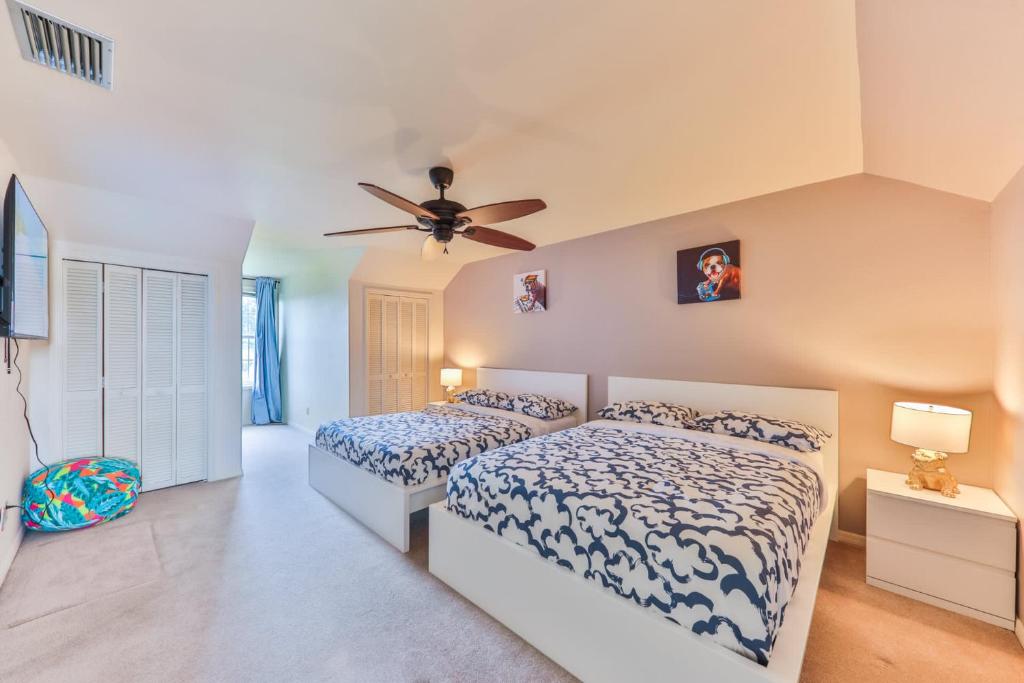 a bedroom with two beds and a ceiling fan at Island Paradise Villa RNT-01125 in Cape Coral