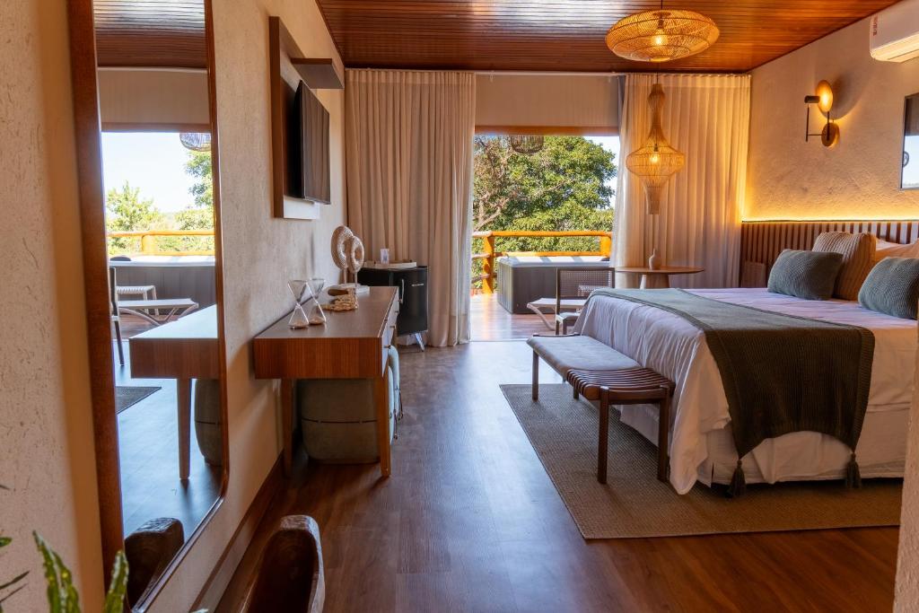a hotel room with a bed and a table and chairs at Pousada K in Pirenópolis
