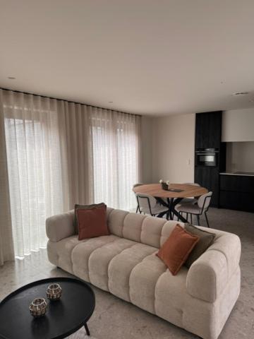 a living room with a couch and a table at The Corner-GILBERT in Oedelem