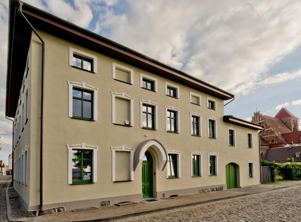 a large building with green doors on a street at Willa Marina in Puck