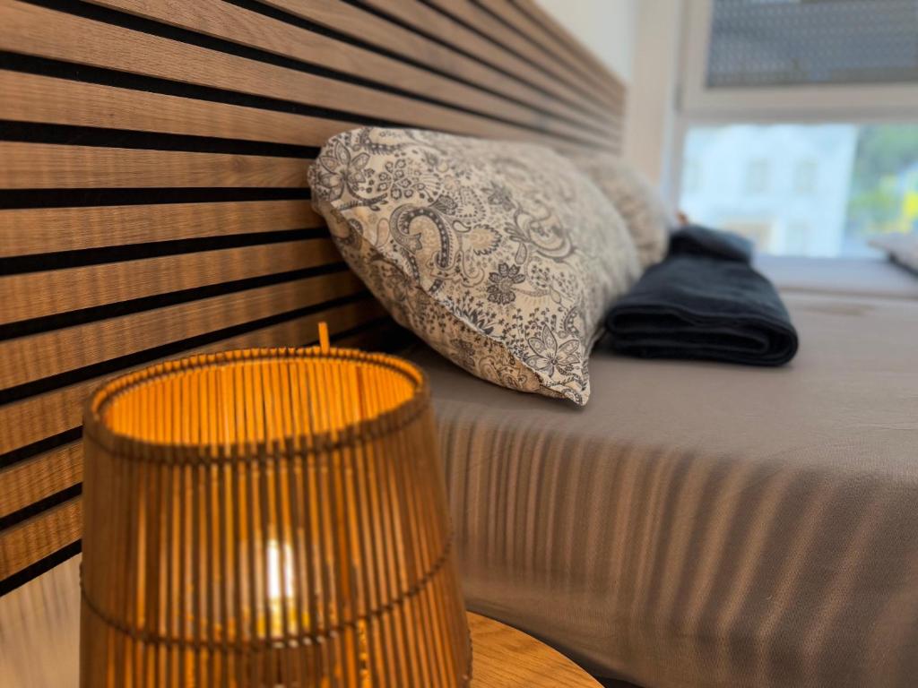 a bed with two pillows and a wooden headboard at Idar Apartments 11 in Idar-Oberstein