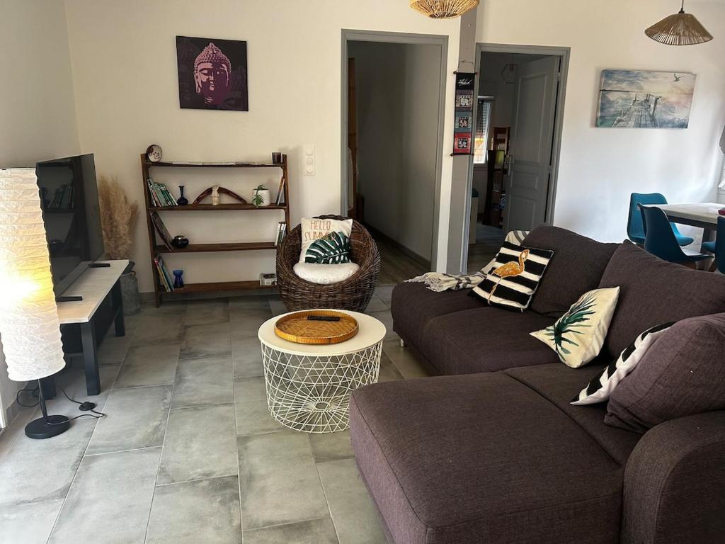 a living room with a couch and a table at Entre Lac et Océan in Hourtin