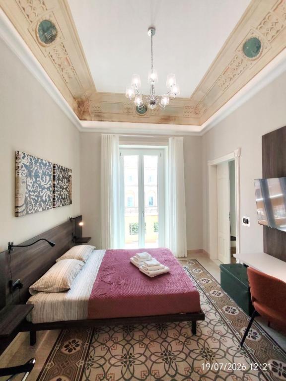 a bedroom with a large bed and a chandelier at Dimora dei Sicani in Aragona