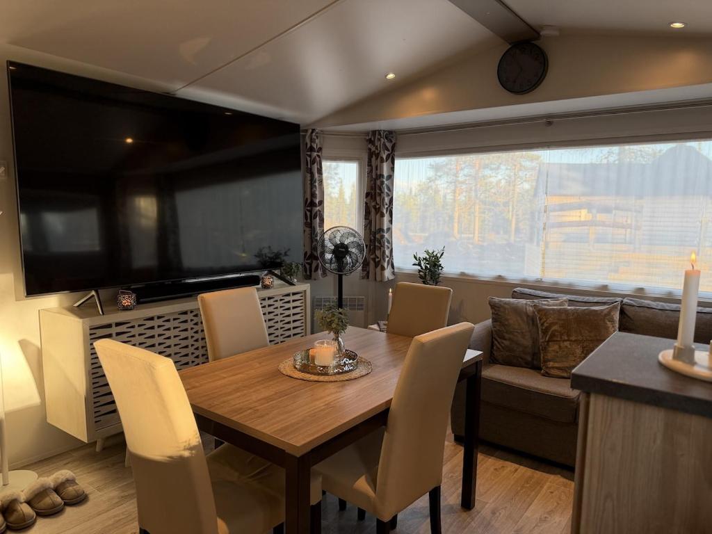 a dining room with a table and chairs and a couch at Tiny House in Jukkasjärvi in Jukkasjärvi
