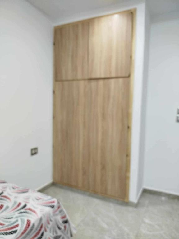 a bedroom with a wooden door in a room at Maison lemjid in Kelibia